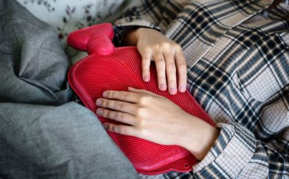 woman using heating pad for stomach pain