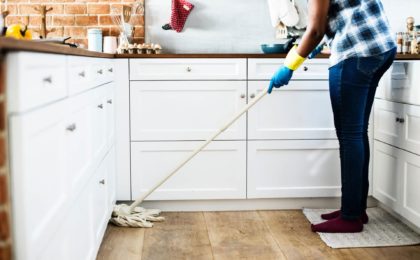 black woman mopping her kitchen floor